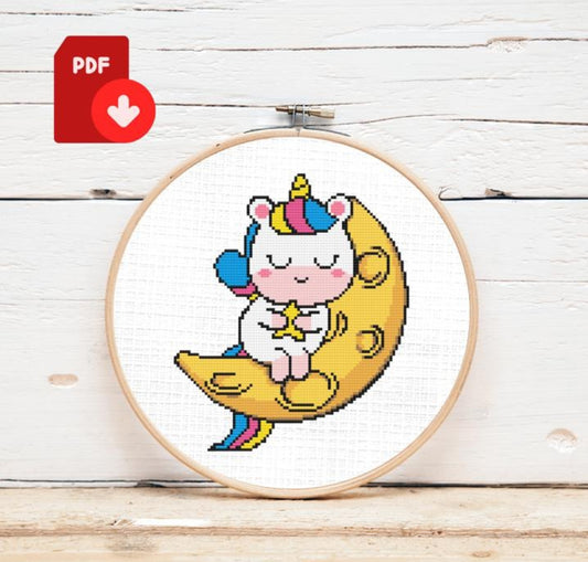 Cross-stitched design of a unicorn on a moon with a PDF icon in the corner.
